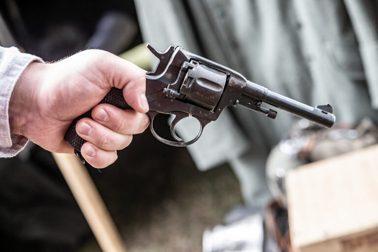 Revolver Nagant 1895 posé sur une caisse en bois – réplique pour location cinéma ou reconstitution historique soviétique.
